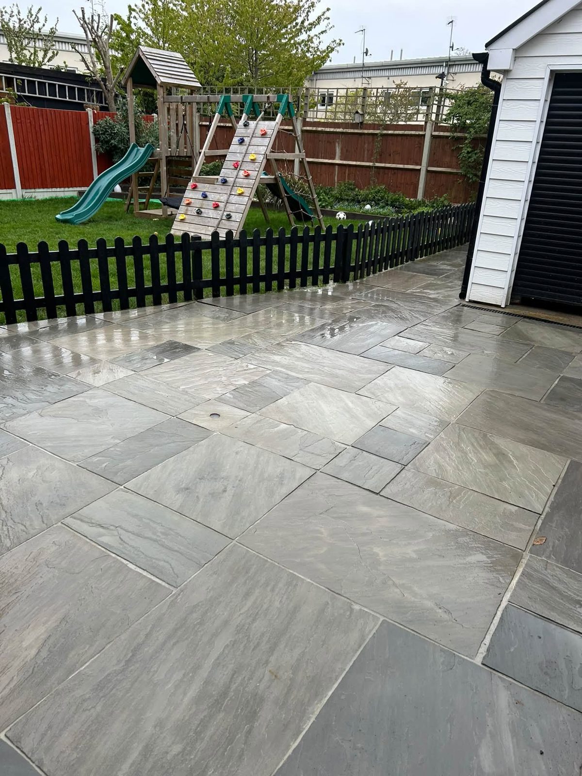After: the same patio fully cleaned with crisp grey sandstone slabs