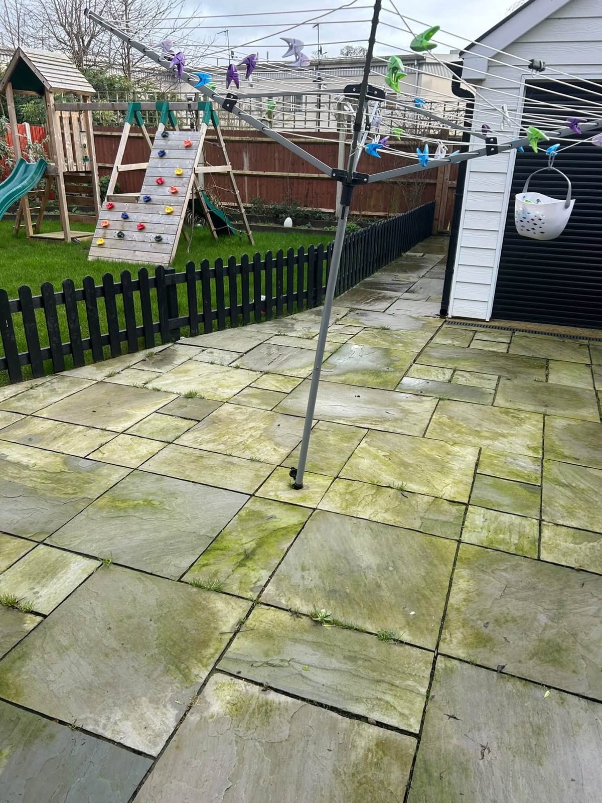 Before: a green, weathered patio beside a children's play area and rotary washing line